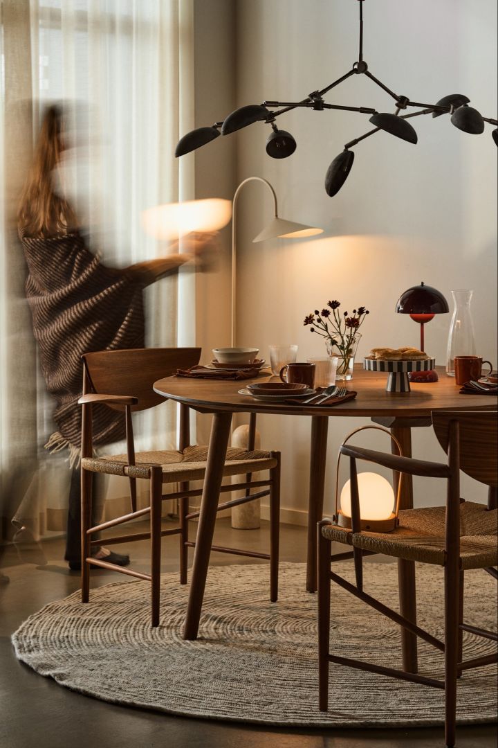 Think about including multiple light sources when it comes to planning your lighting. Here you see a dining table with lots of different table lamps and a dramatic ceiling lamp. 