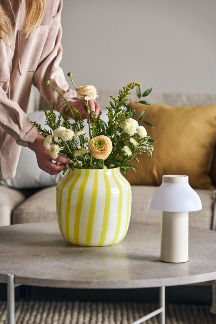 Brighten your living room with a beautiful bunch of flowers in a the lively Juice vase in yellow from HAY. 
