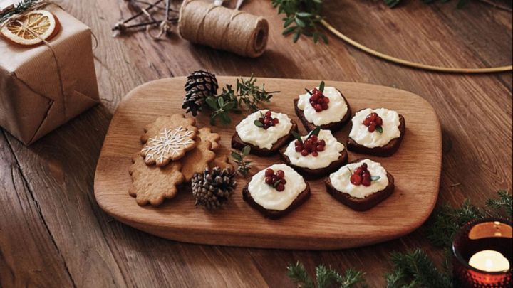 Soft gingerbread with frosting is served on a wooden cutting board - a Scandinavian Christmas recipe to try this Christmas.