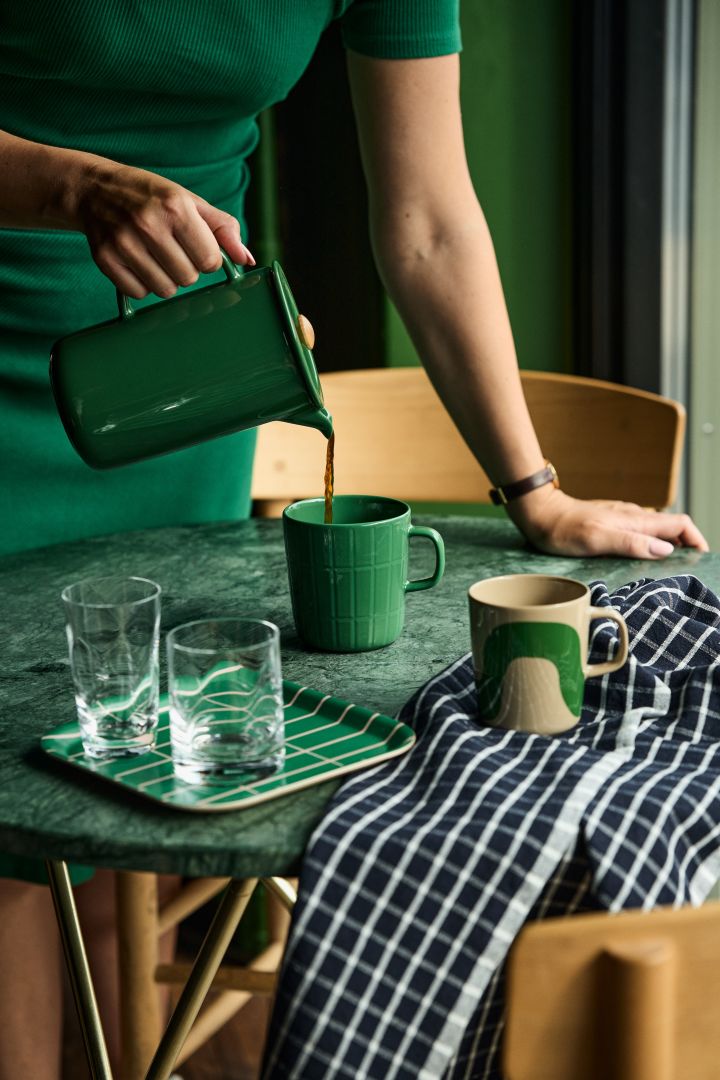 A beautiful shade of dark green is making its way into the autumn 2023 interior design trends and also into tableware. Here, Marimekko jugs and mugs in green. 