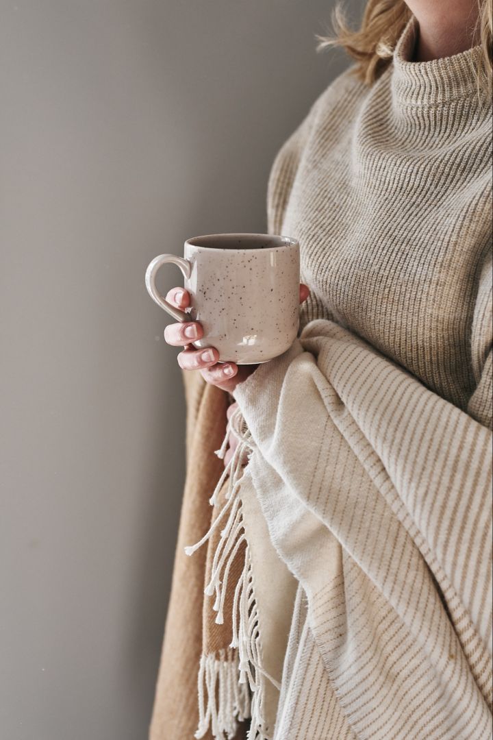 Make it hygge is one part of an Scandinavian interior design-feeling - here with a cozy throw and mug from Scandi Living. 