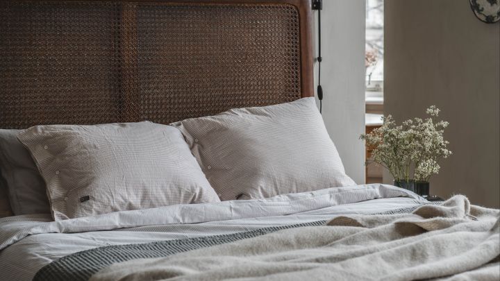 A soft inviting bed in a cosy, calming bedroom- 
