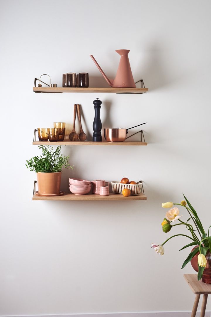 The Pythagoras shelf from Maze in a neutral kitchen with pink and orange coloured item.