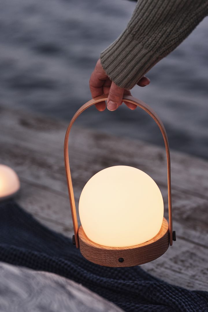 Here you see the Scandinavian design lamp Carrie from Audo Copenhagen, here on a dock by the sea. 