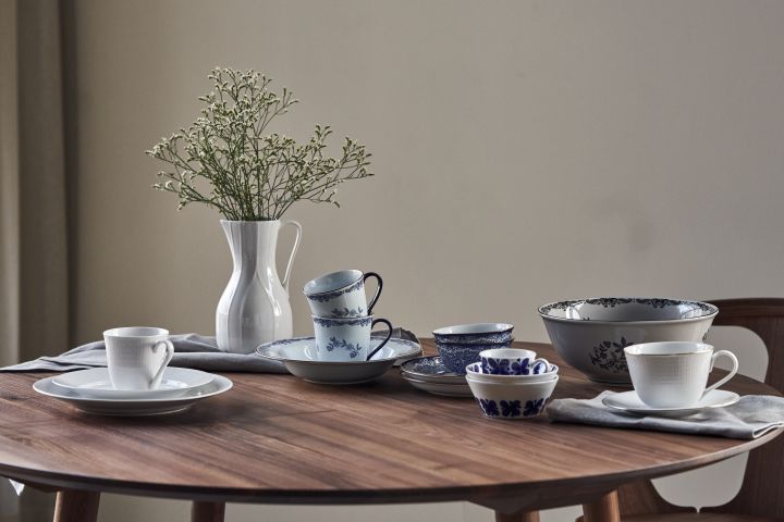 Rörstrand's porcelain classics are lined up on a round table: Mon Amie, Swedish Grace, Ostindia in blue and black and the Pli Blanc jug. 