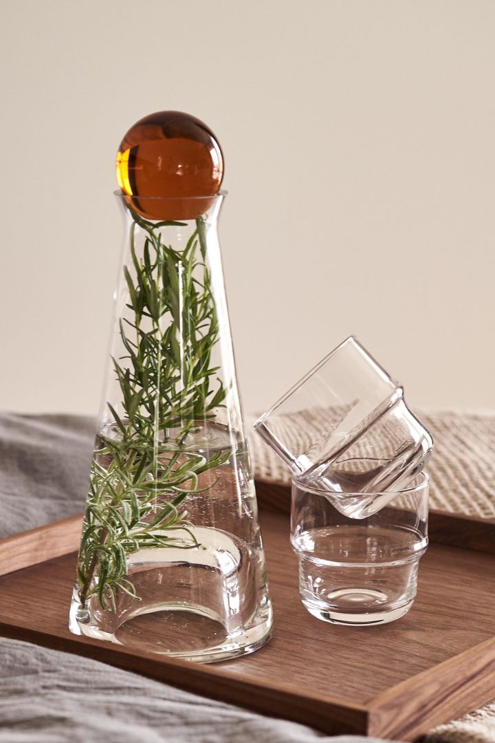 Here you see the Fia Carafe with amber stopper and a sprig of rosemary with the NM& Glasses all from Design House Stockholm. 