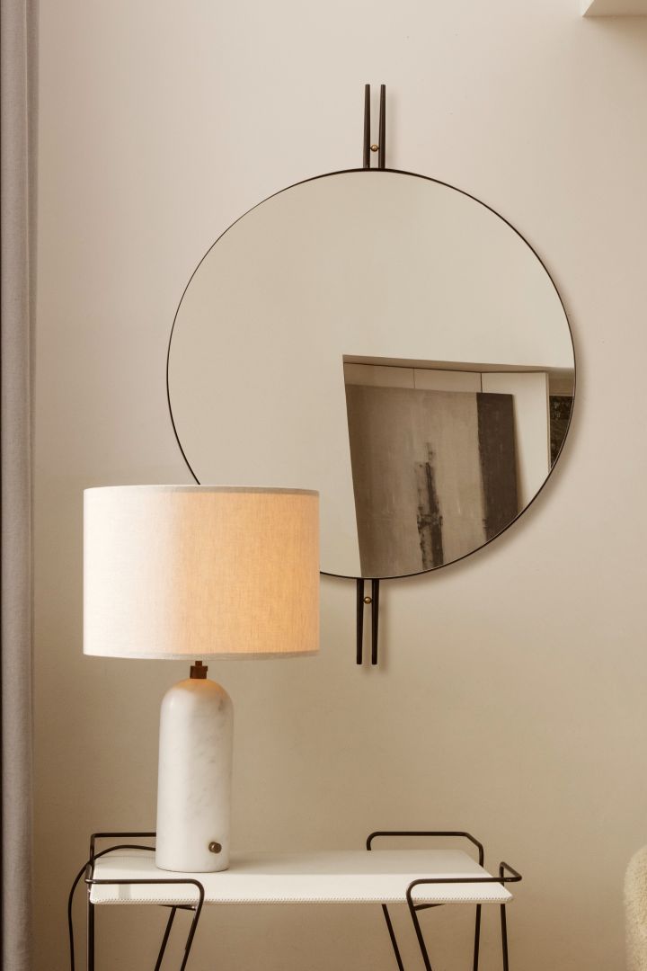 Discover GUBI's top tips for placing lighting in your home. Here you see the GUBI Gravity table lamp in white marble on a side table in front of a mirror.