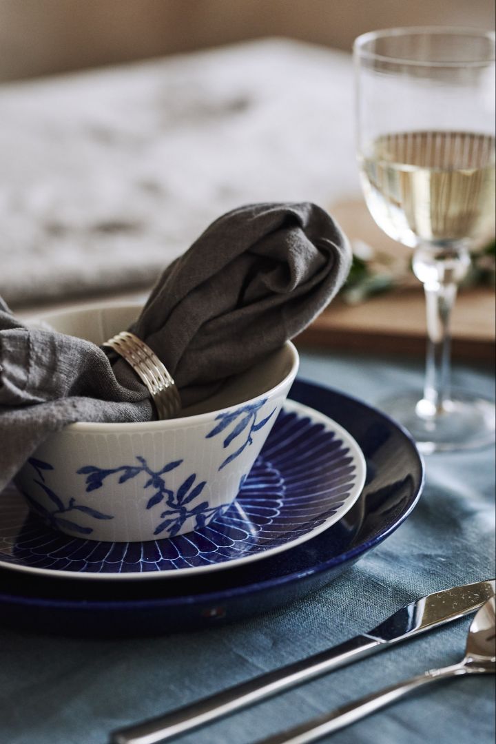 A mixed blue and white table setting with porcelain such as a Selma plate from Götefors porcelain and a blue Teema plate from Iittala.