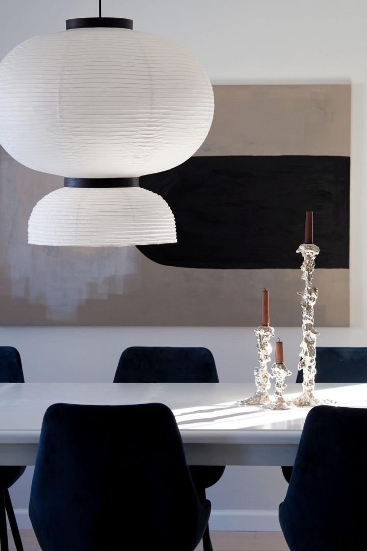 11 stylish ceiling lights to decorate your home with - here you see the Formakami ceiling light from &Tradition hanging over a black and white dining table. 