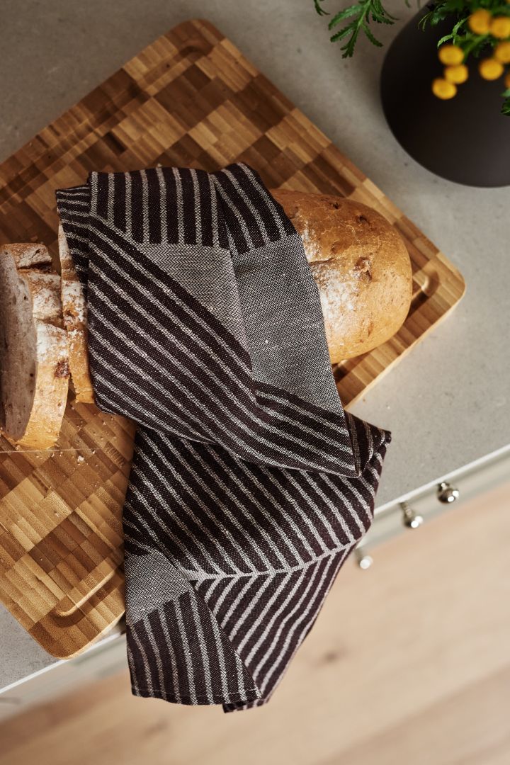 Renew your kitchen with 11 practical and stylish kitchen accessories for easier cooking - here you see the stylish Stripes kitchen towel from NJRD in brown and white.