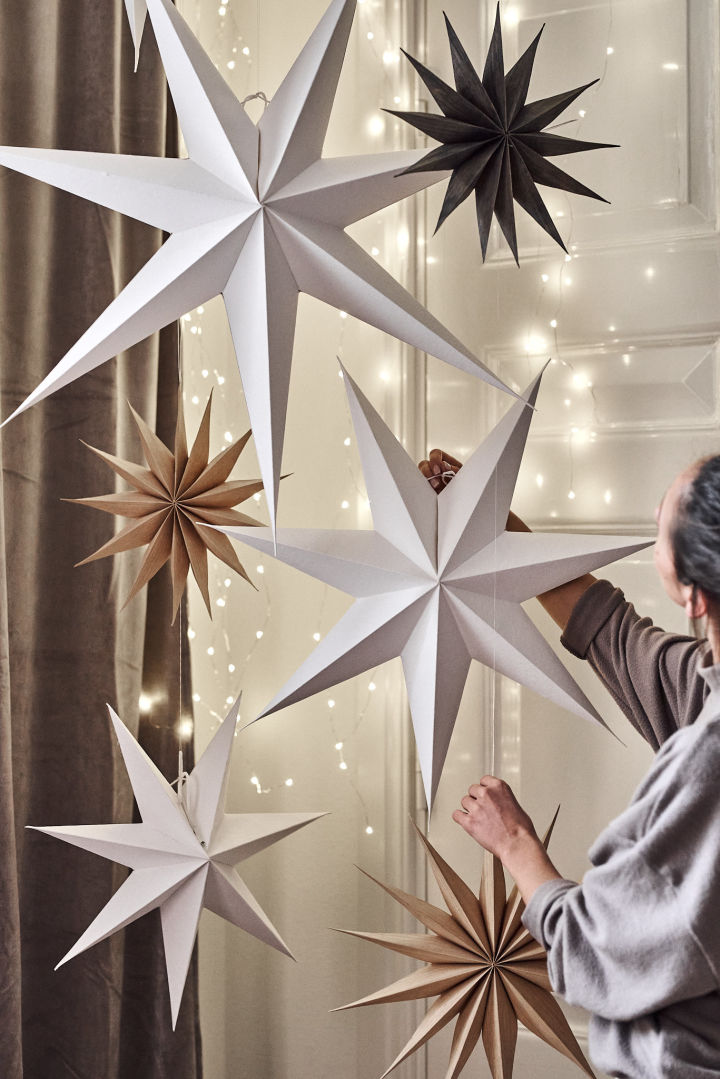 Minimalist Christmas decor with paper Christmas stars hanging from the ceiling of a home.